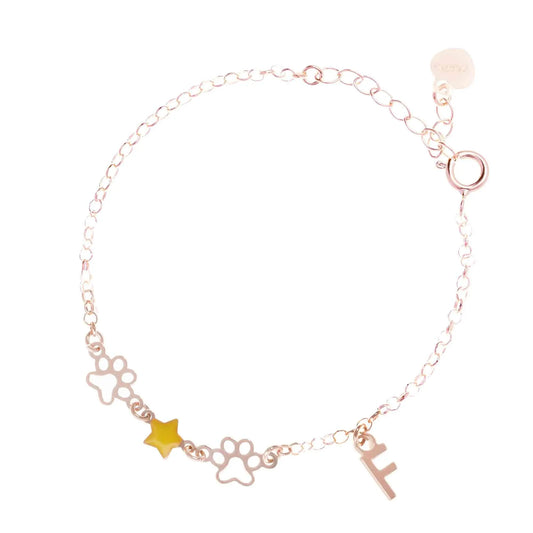 Bracciale regolabile in argento 925 rose’ con due zampine sagomate, stella smaltata gialla e letterina pendente.